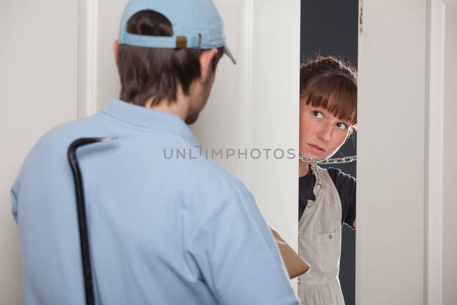 criminal delivery man with crowbar and package - woman opens the door