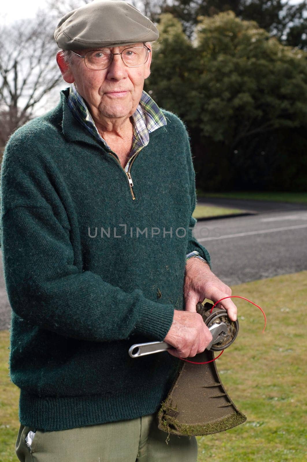 senior man fixing lawn trimmer