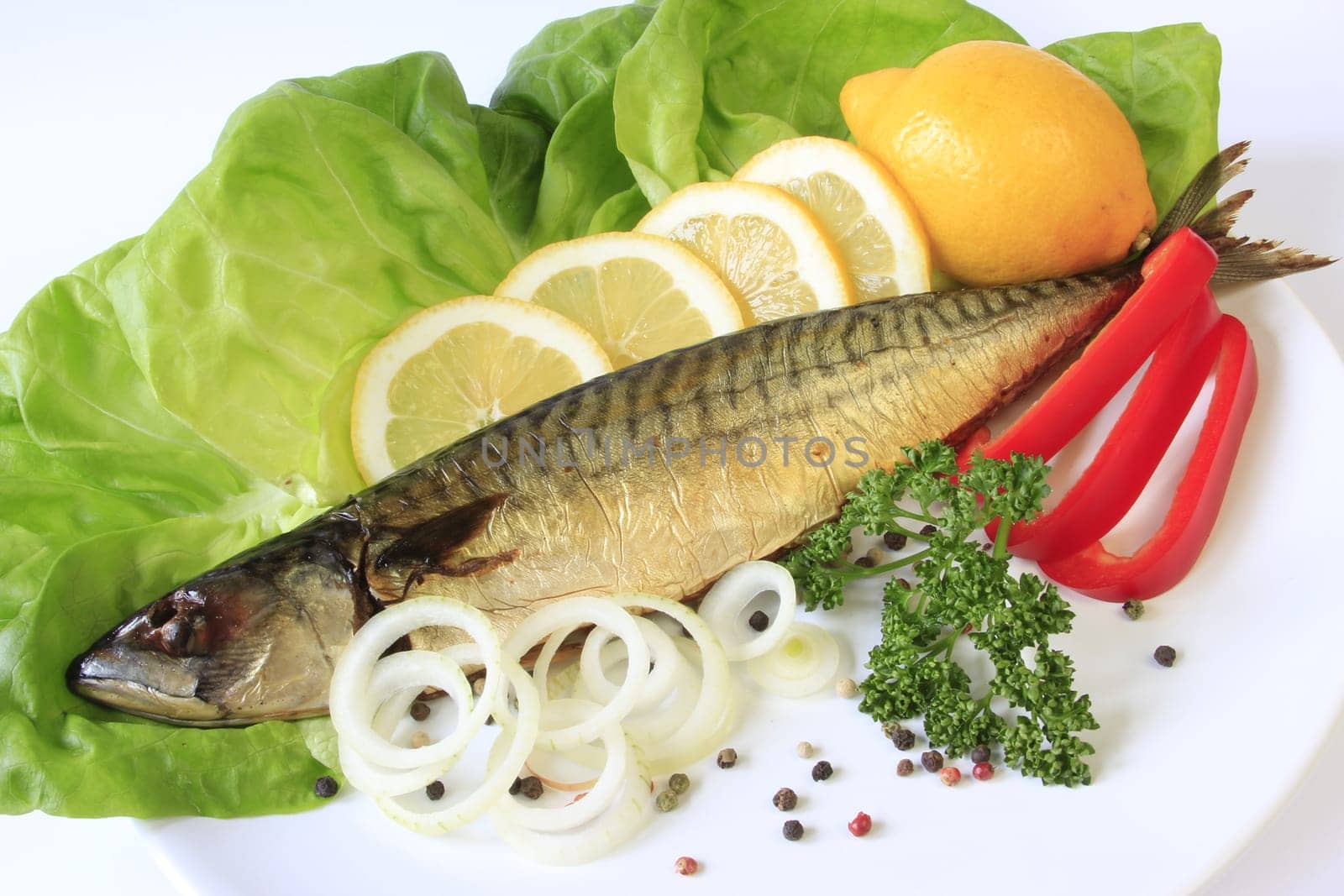 Smoked mackerel decorated with lemon on lettuce leaves