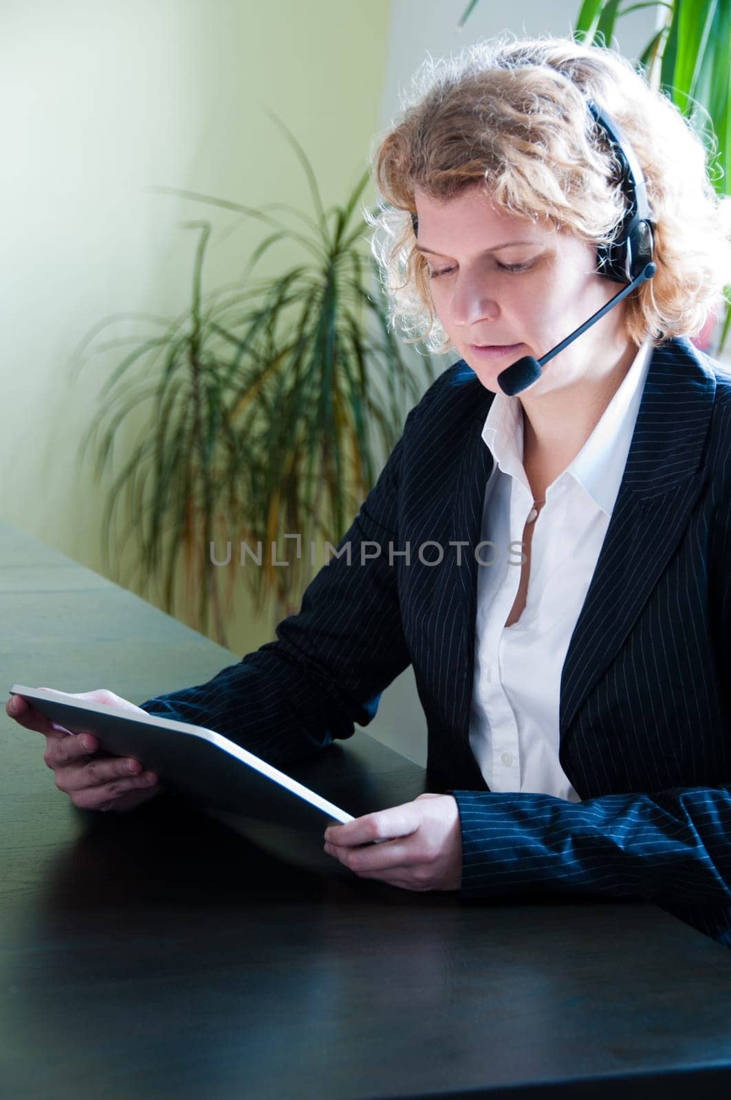 Closeup of a business woman with  tablet pc and headset