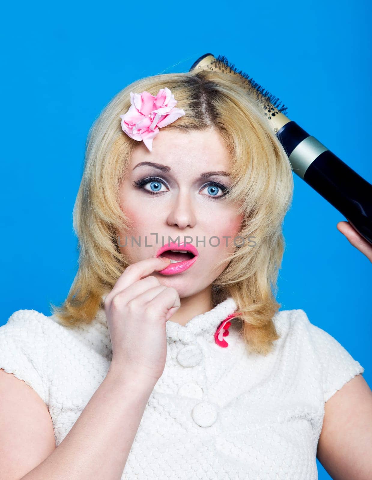 Young blond with hairdryer studio shot pin-up style