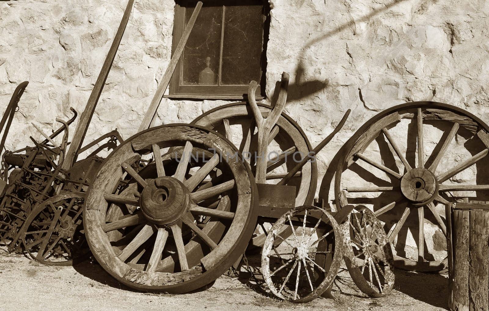 old brown image of wheels and tools outside the blacksmith shop