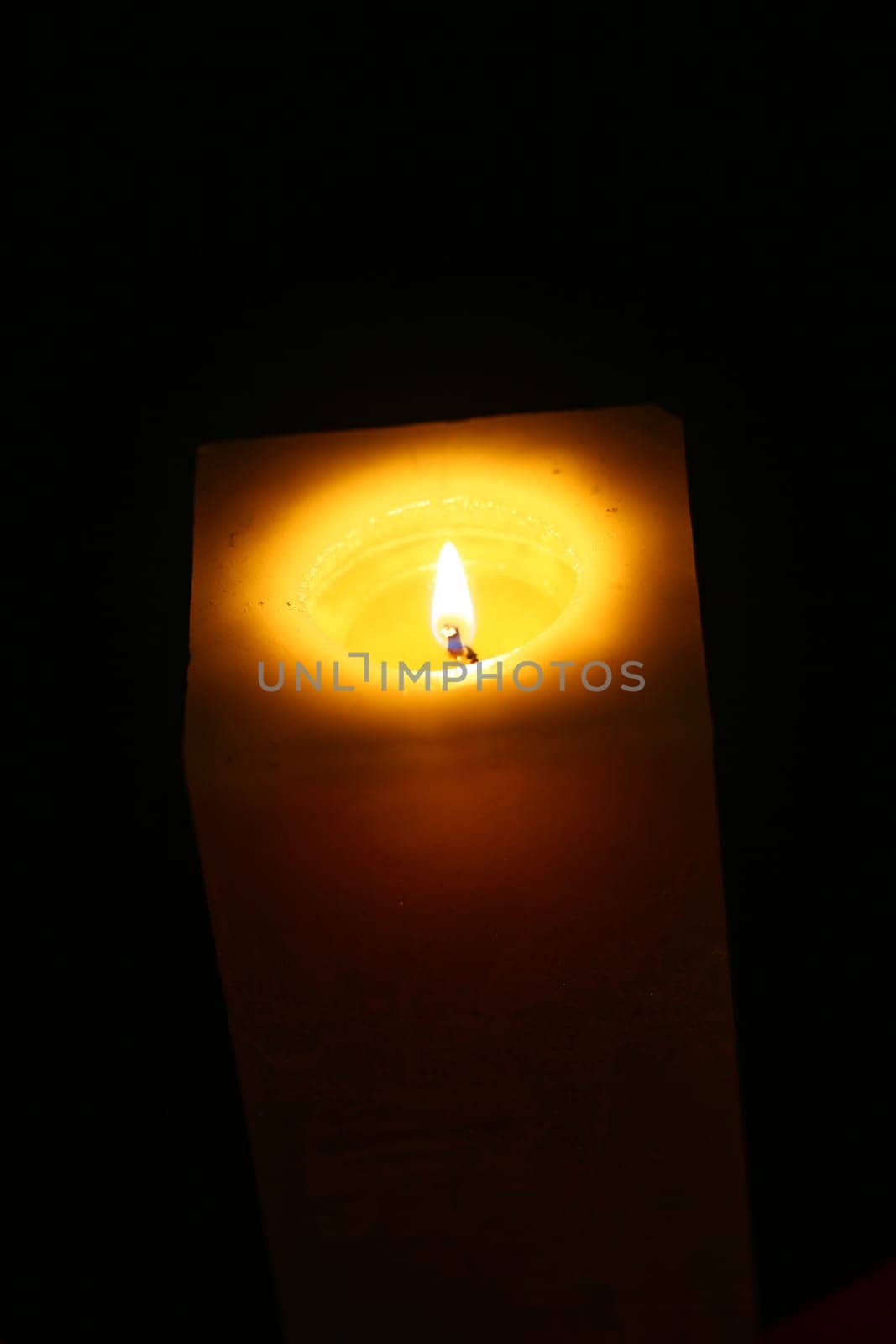 Close-up candle illuminates the darkness of the night environment