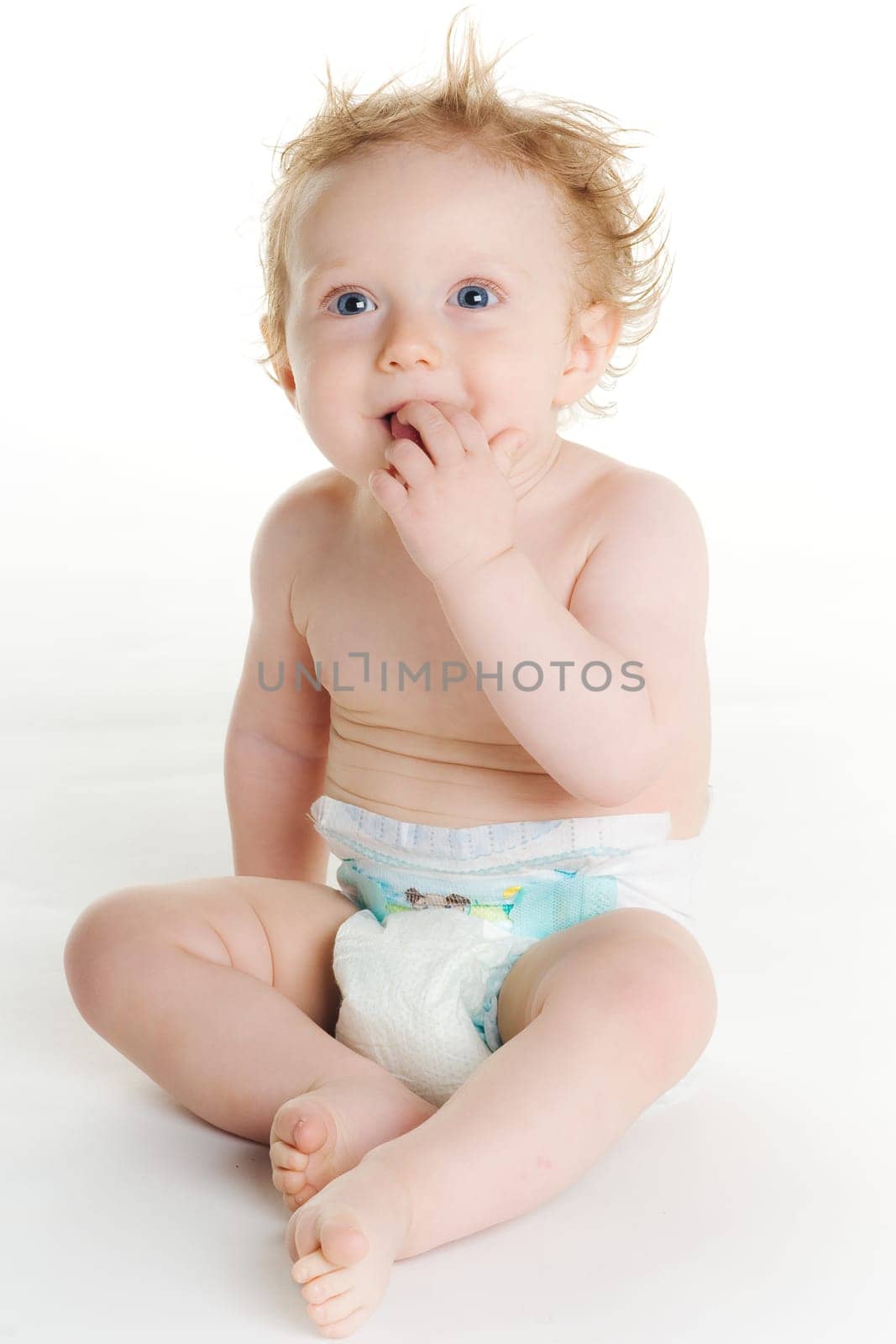Cute baby in diaper playing on white