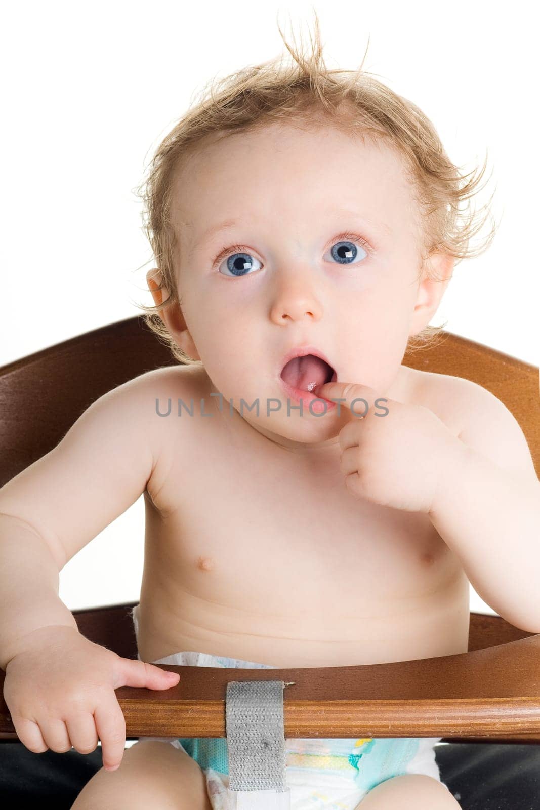 Cute hungry baby in dining chair with white background