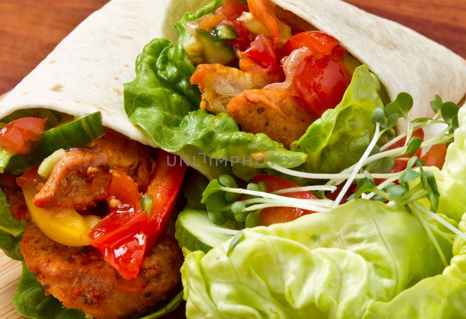 Spicy chicken with salad and salsa wrapped in a soft flour tortilla.