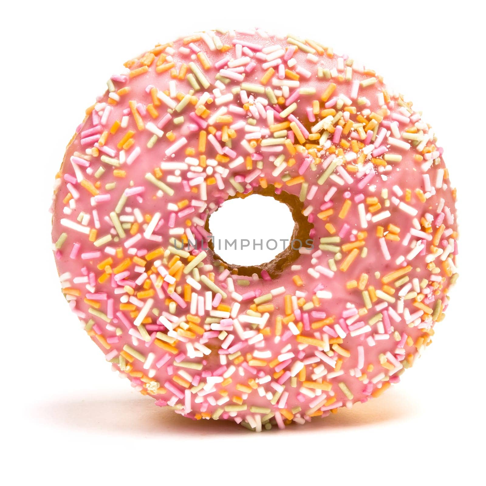 Pink Iced Doughnut covered in sprinkles isolated against white background.