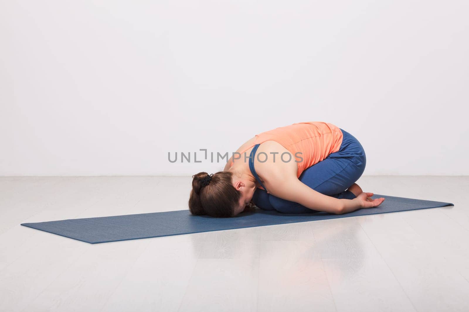 Beautiful sporty fit yogi girl practices yoga asana balasana by dimol