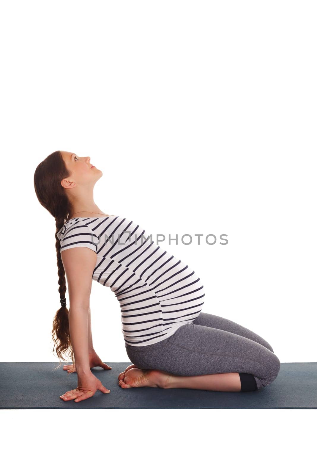 Pregnancy yoga exercise - pregnant woman doing yoga asana Ustrasana Camel Pose easy Variation Hands On Floor isolated on white background