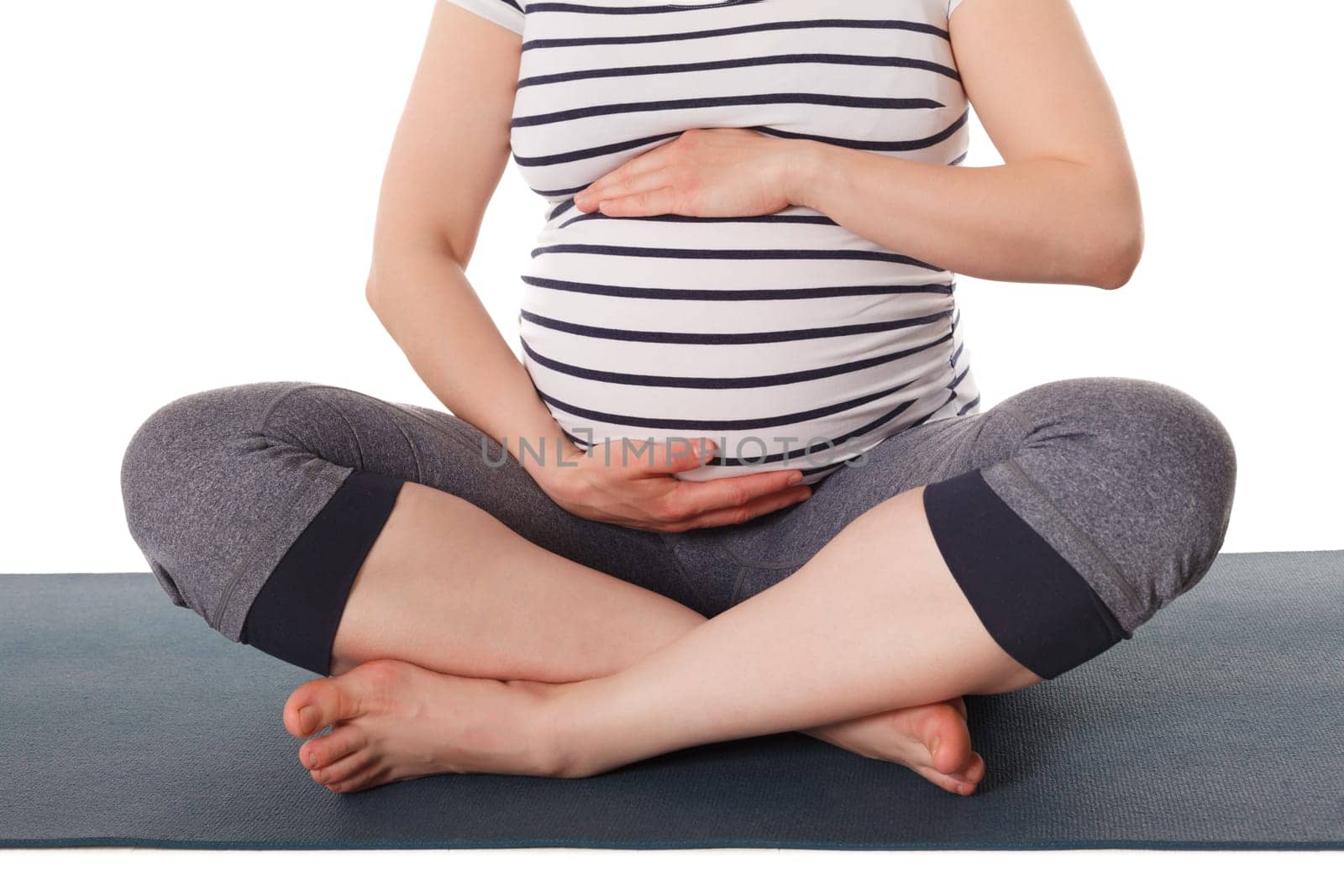 Pregnant woman doing yoga asana asana Sukhasana by dimol