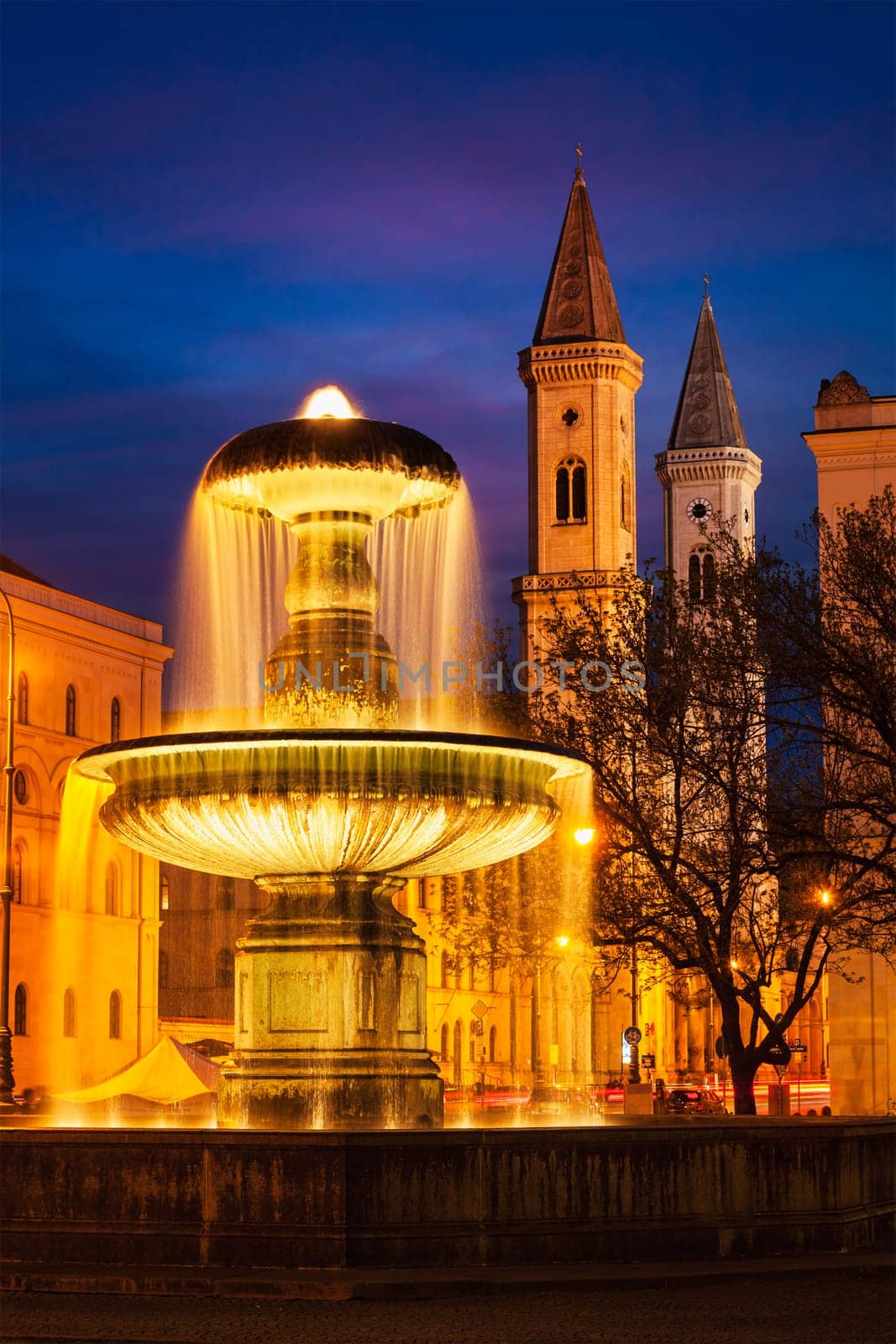 Fountain in the Geschwister-Scholl-Platz and St. Ludwig's Church (Ludwigskirche) in the evening. Munich, Bavaria, Germany