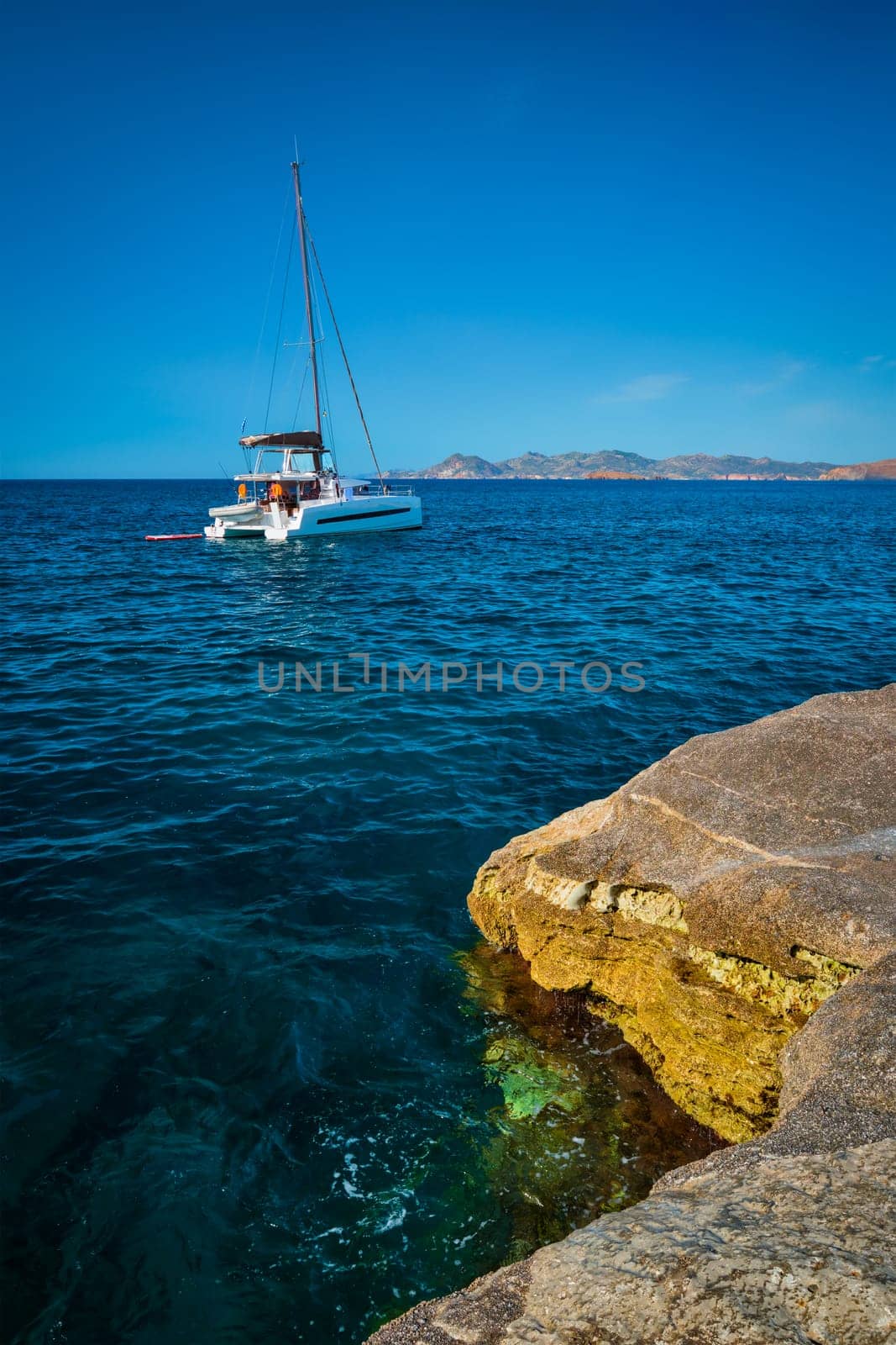 Yacht boat in Aegean sea at white rocks of Sarakiniko Beach, Milos island , Greece