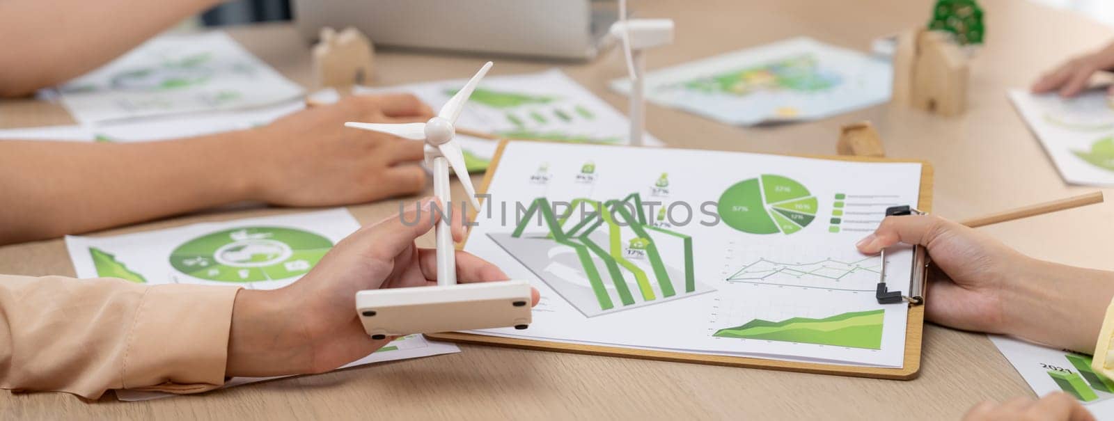 Green business meeting represented renewable energy. Skilled businesspeople discuss green business investment at table with environmental documents. Closeup. Focus on hand. Delineation.