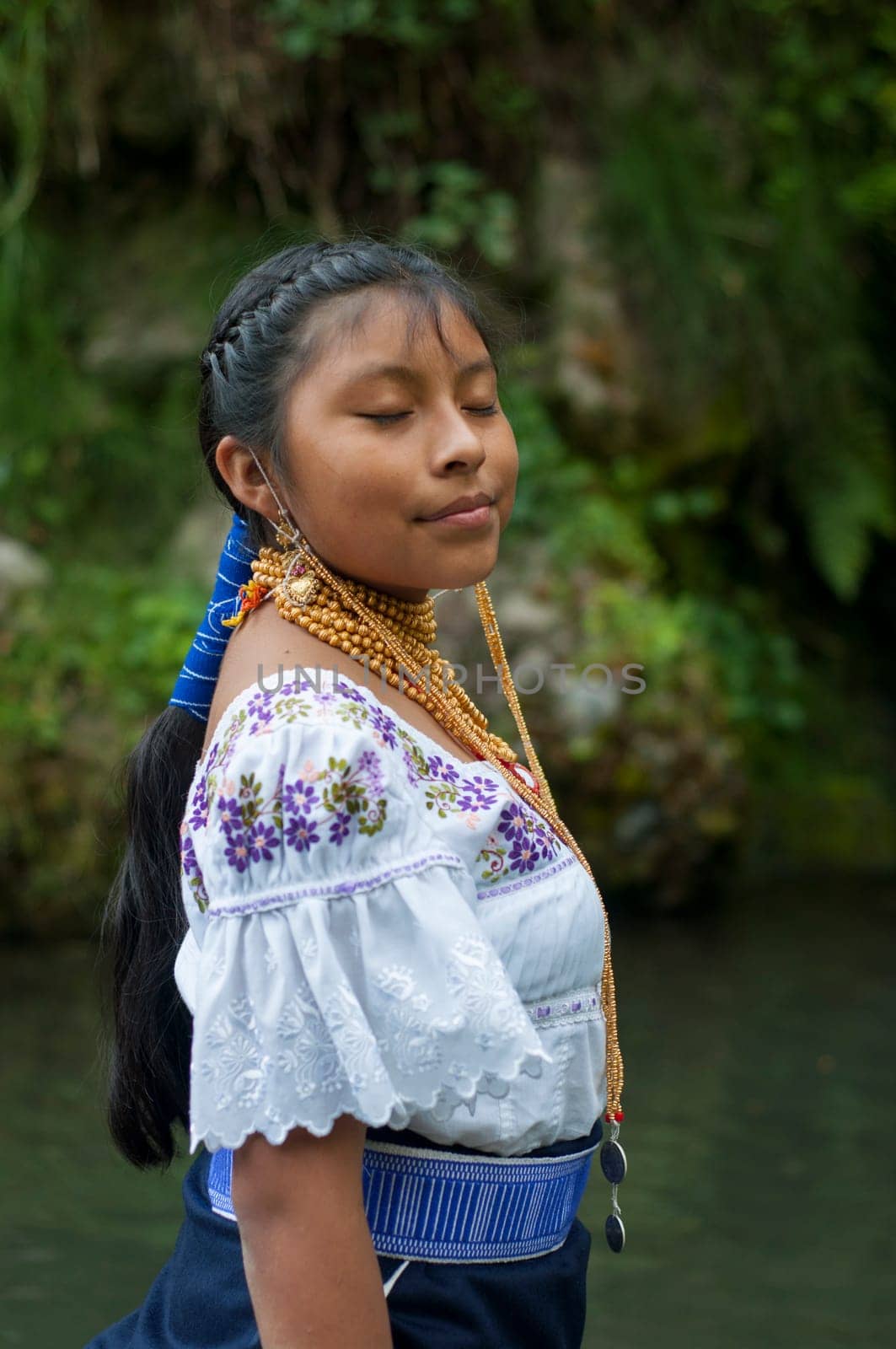 young indigenous woman from Ecuador next to a lake working on her mental health with breathing and relaxation exercises. High quality photo