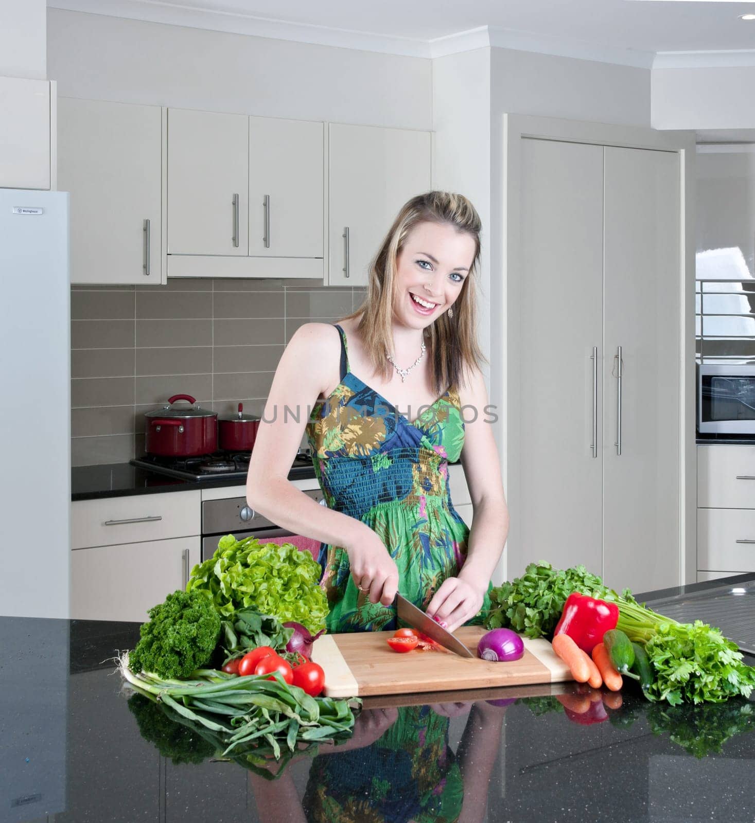 pretty young woman chopping and preparing vegetables