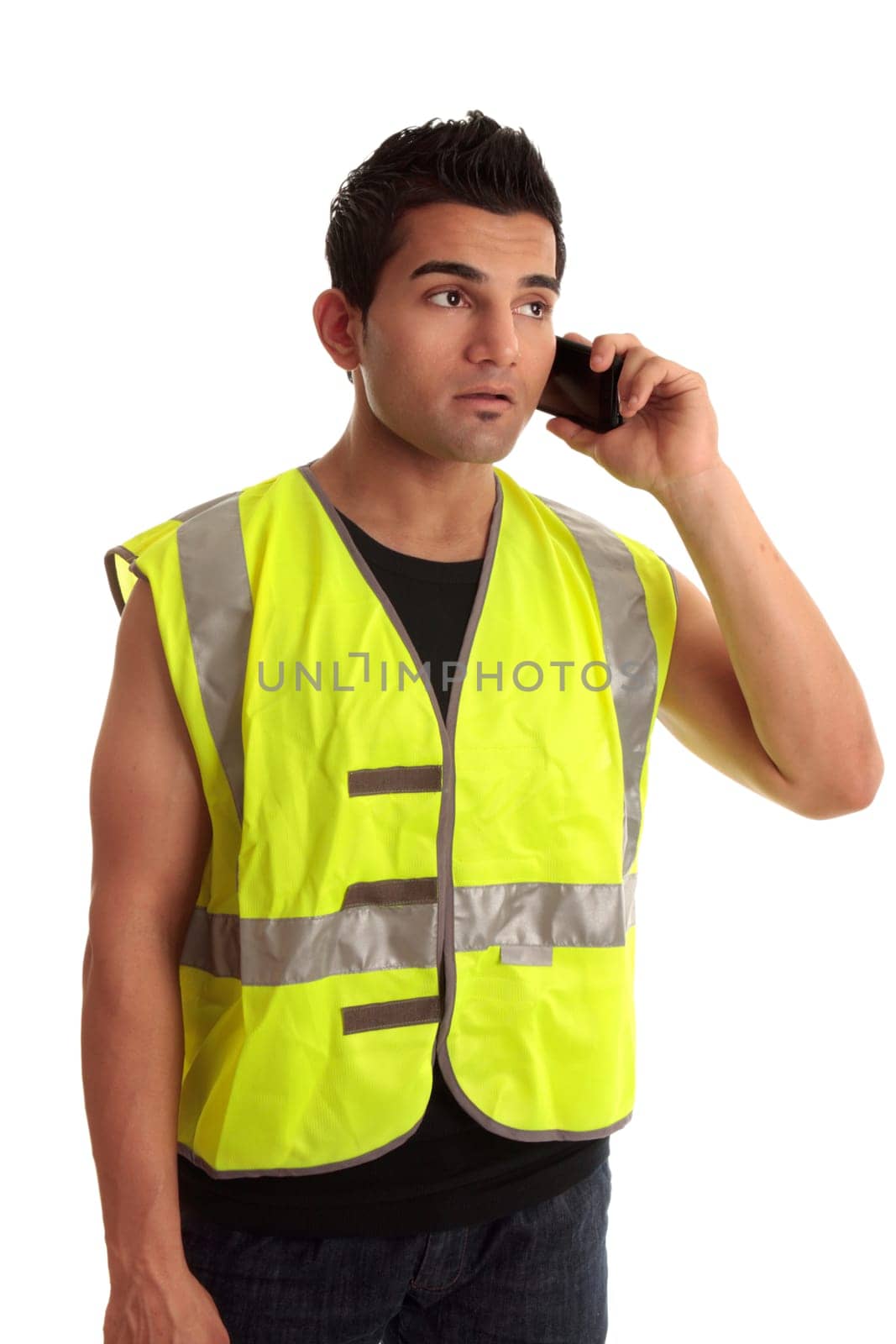 Construction worker in safety vest receives a call on a mobile phone.