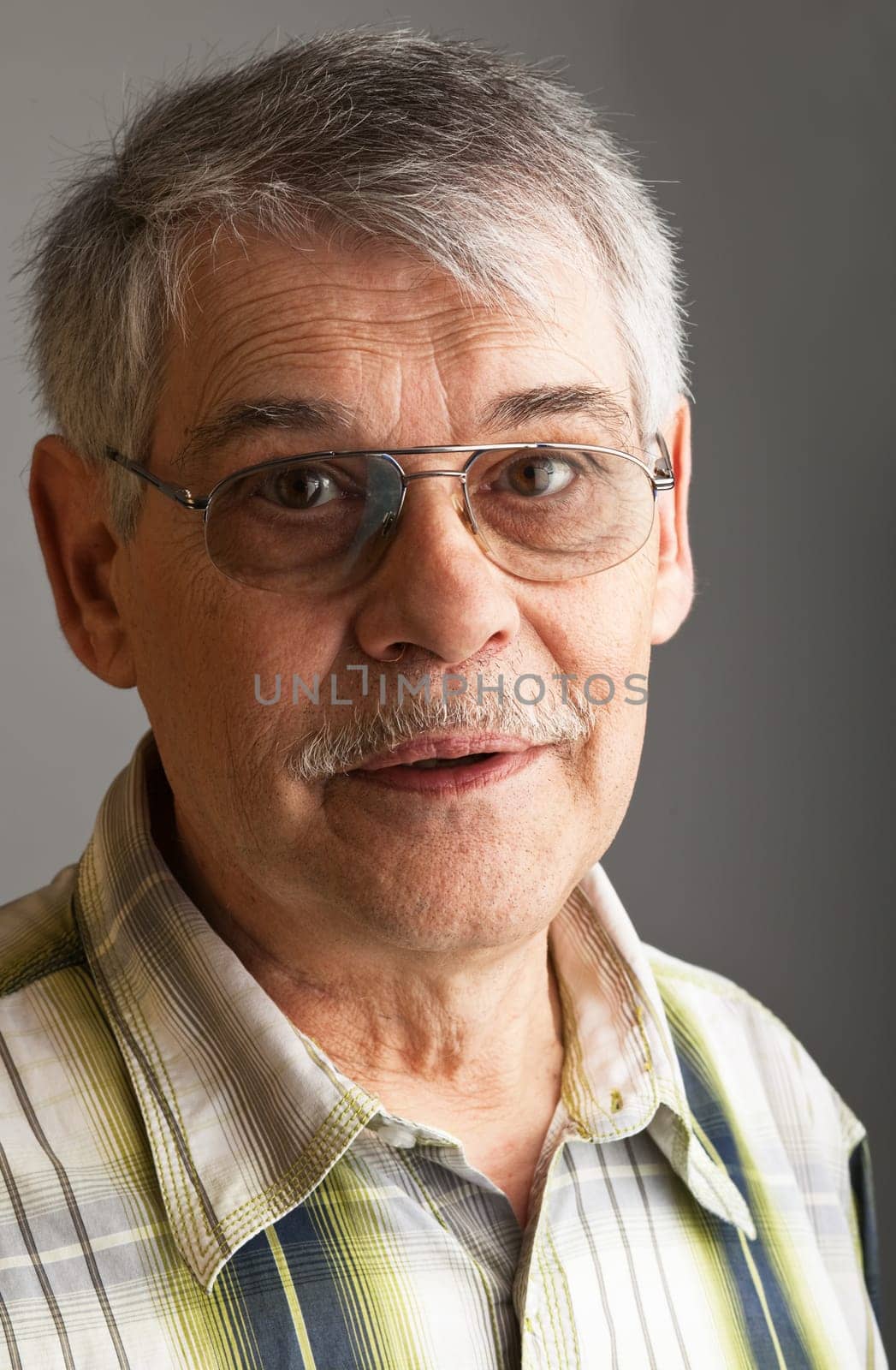 Portrait of a mature man over gray background