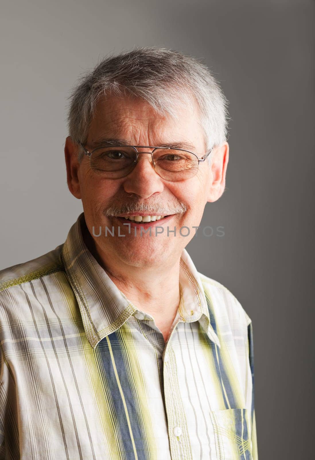 Portrait of a smiling mature man over gray background