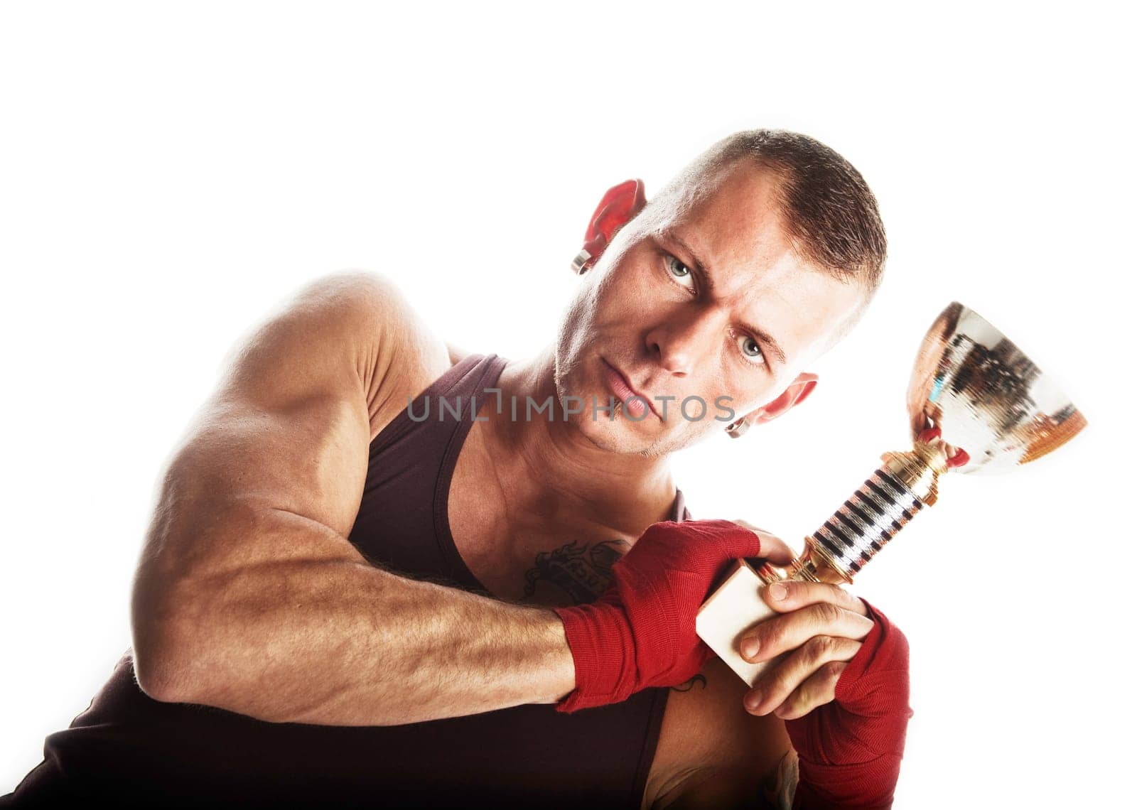 Muscular sportsman holding his chamption cup  isolated on white