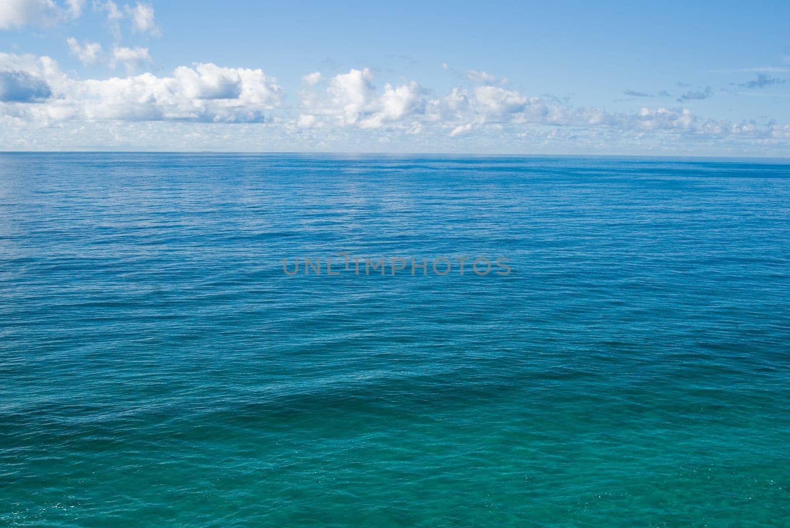 the flat and calm deep blue tropical ocean