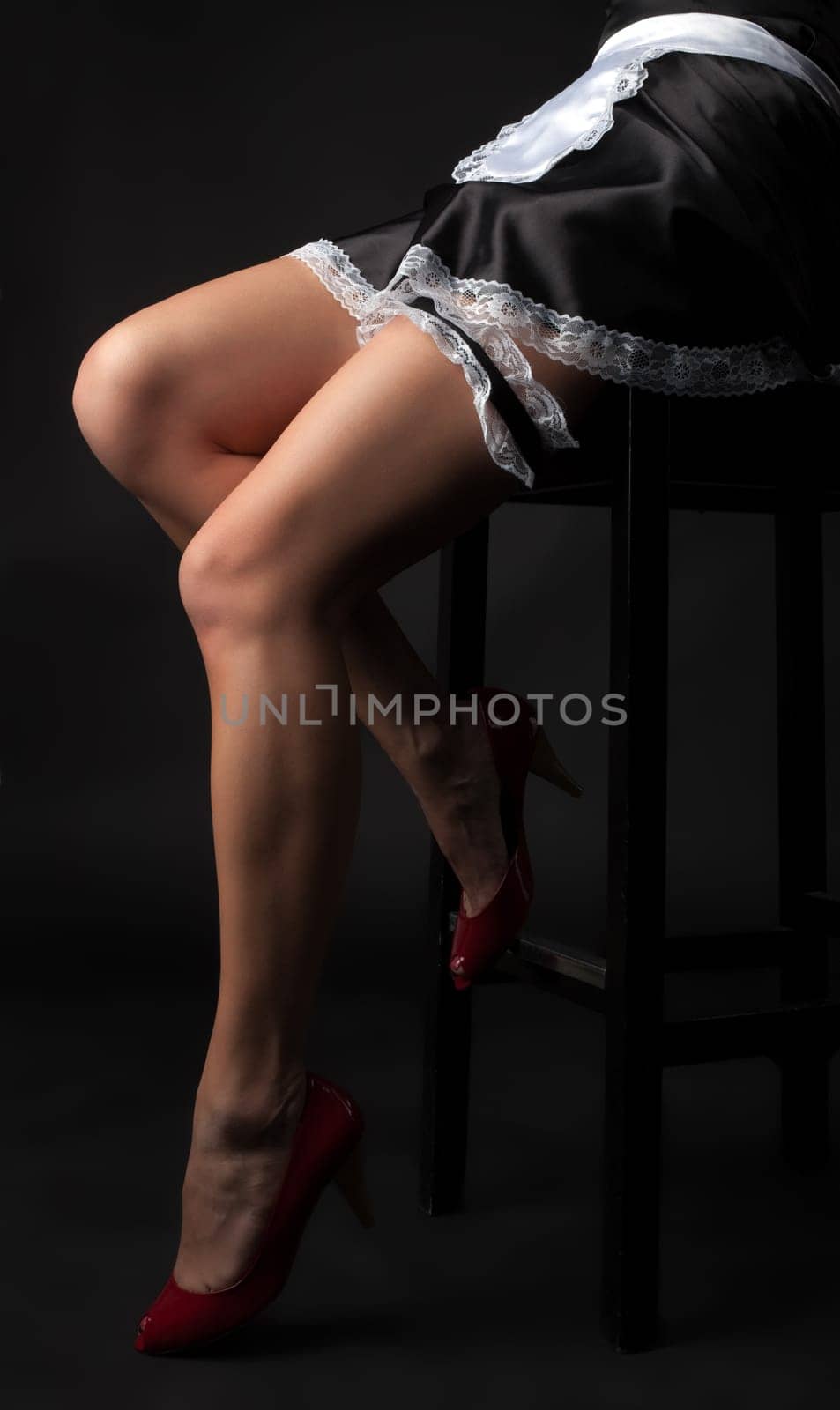long woman legs in nurse dress sit on chair