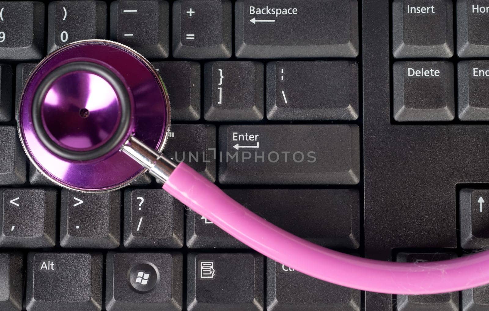 pink stethoscope on a computer keyboard