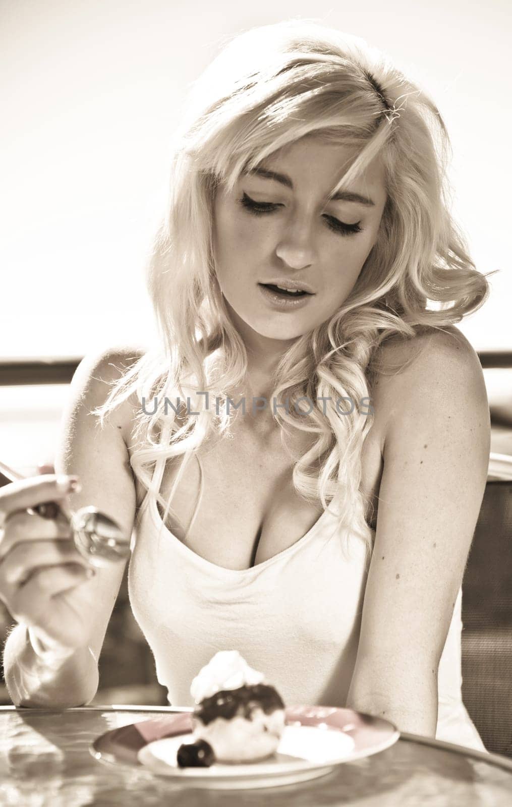 young woman has wine and dessert in cafe