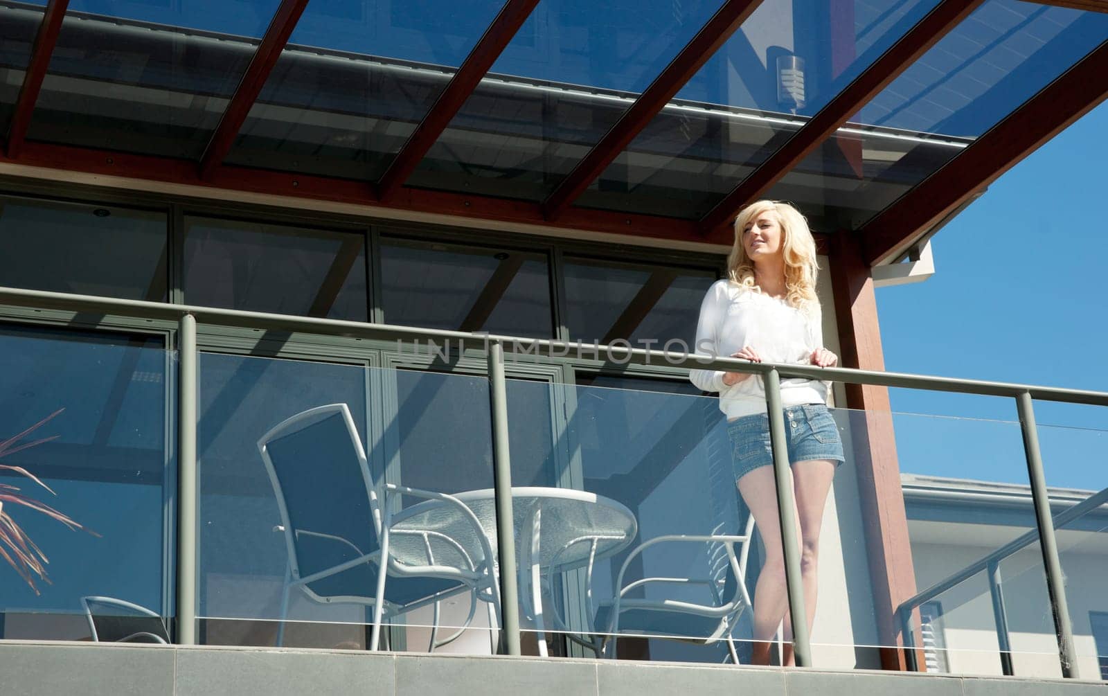 beautiful young woman looks out from the balcony