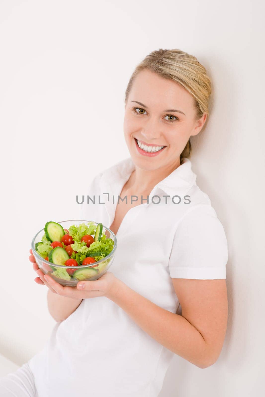 Healthy lifestyle - smiling woman with vegetable salad on white