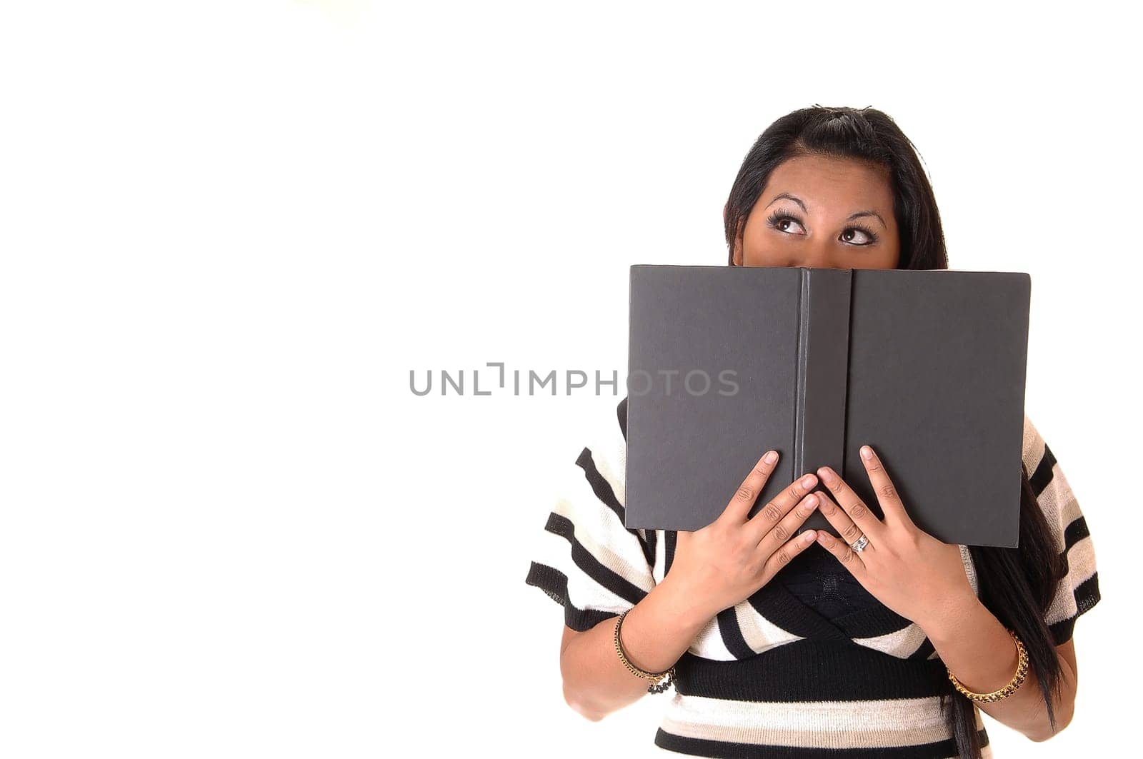 A young Asian woman thinking about what she is reading in the book what she is holding on her face, for white background.