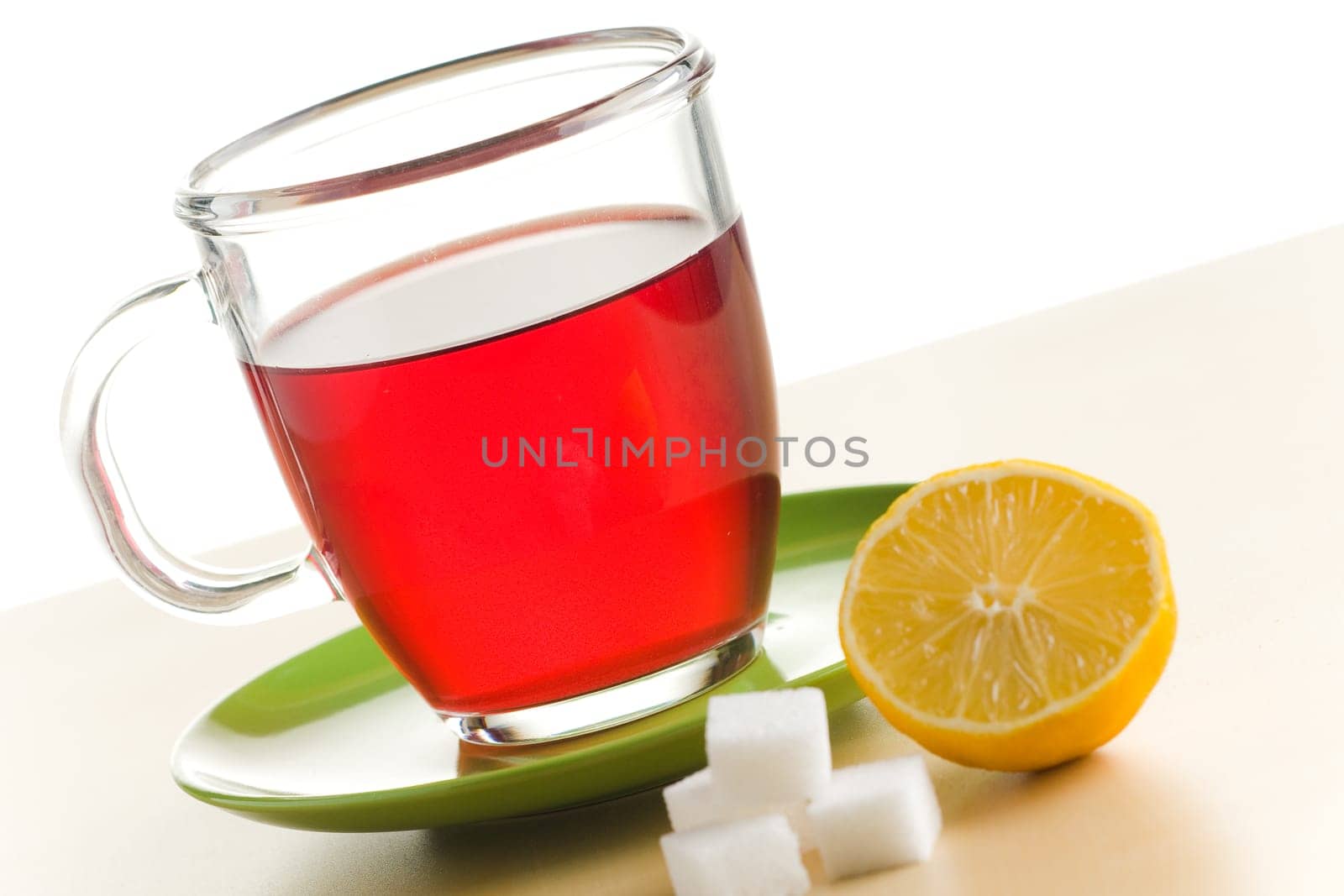 Transparent tea cup with red tea,lemon and sugar