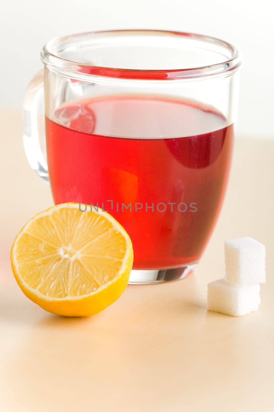 Transparent tea cup with red tea,lemon and sugar
