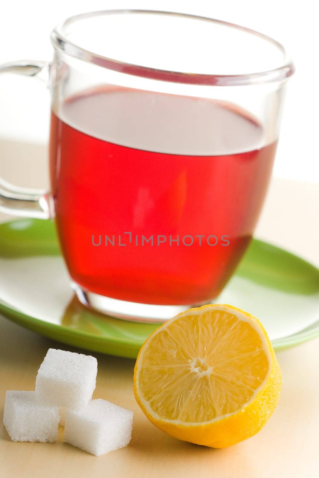 Transparent tea cup with red tea,lemon and sugar