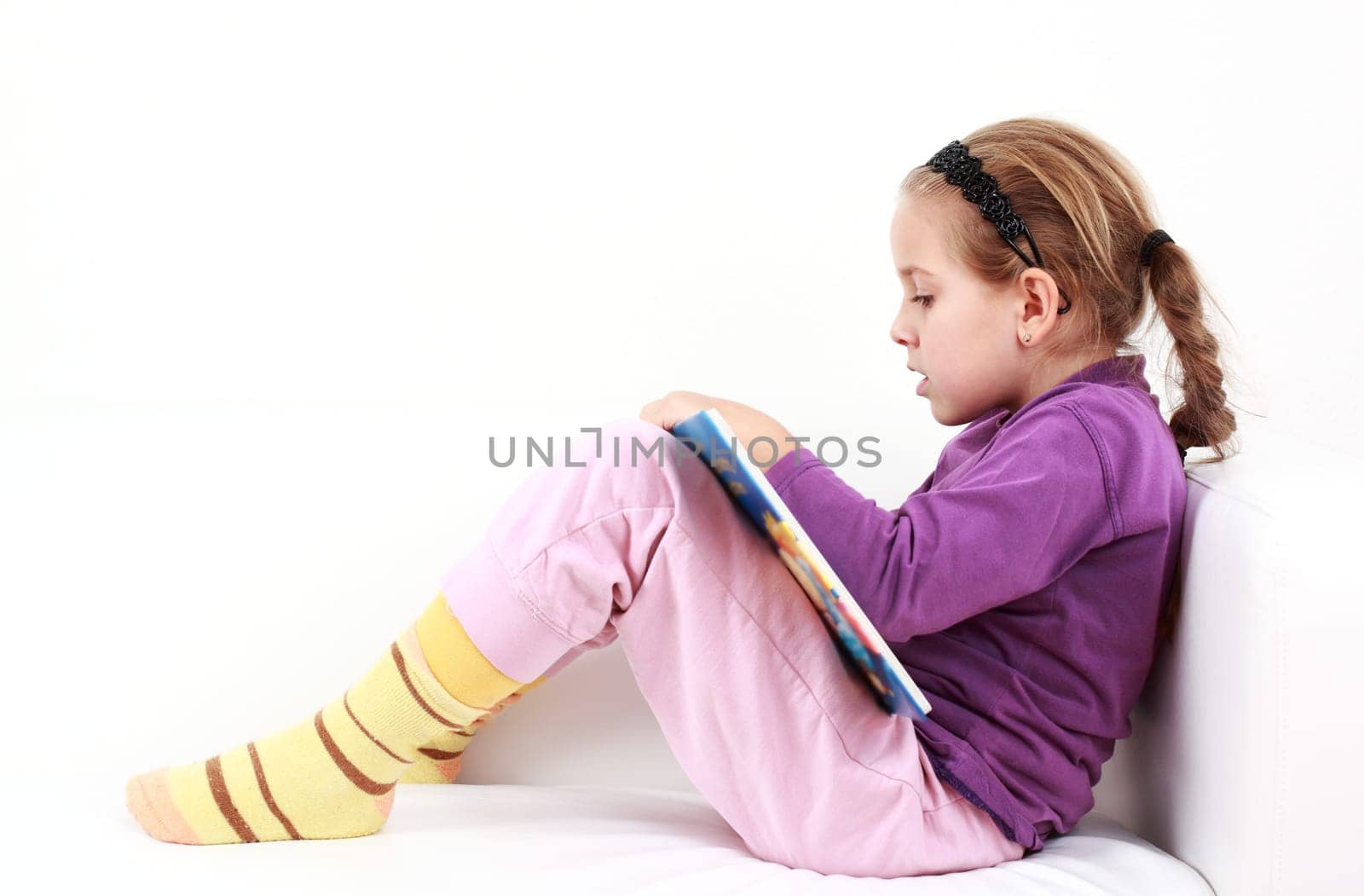 Cute little girl reading a book