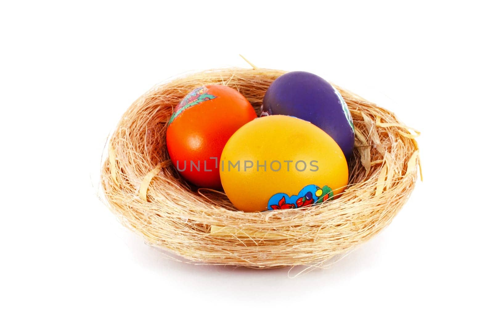 Colored Easter eggs in nest of grass isolated on white