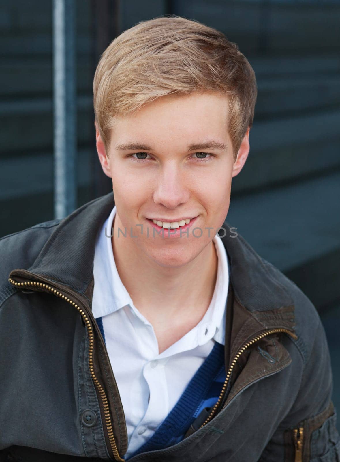 Portrait of smiling blond handsome young man outdoors