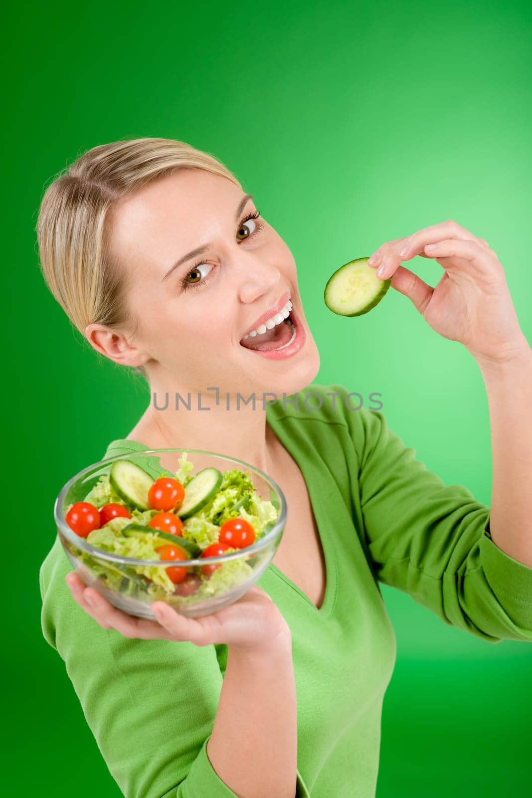 Healthy lifestyle - woman holding vegetable salad on green background