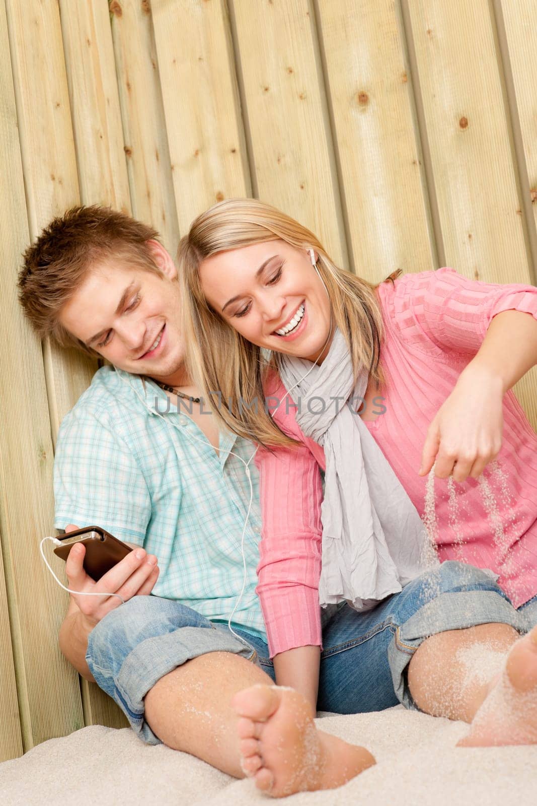 Couple in love - summer fun on beach listen to music
