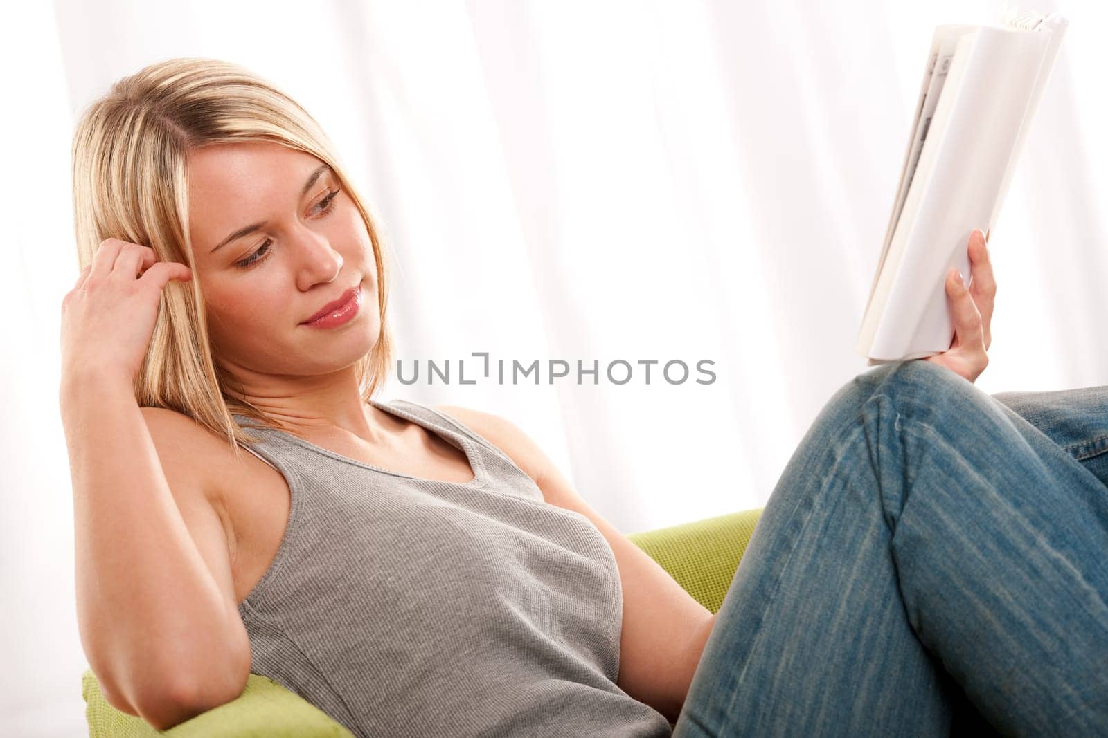 Blond young woman reading book