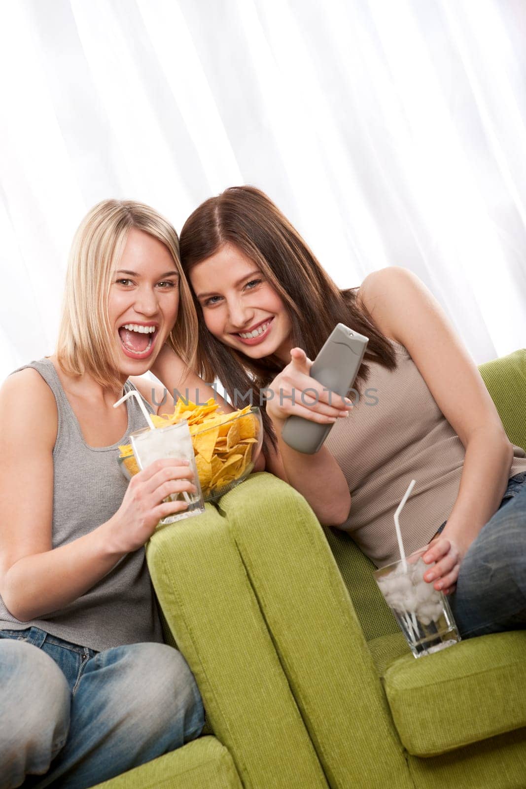 Blond girl and brunette watchning television