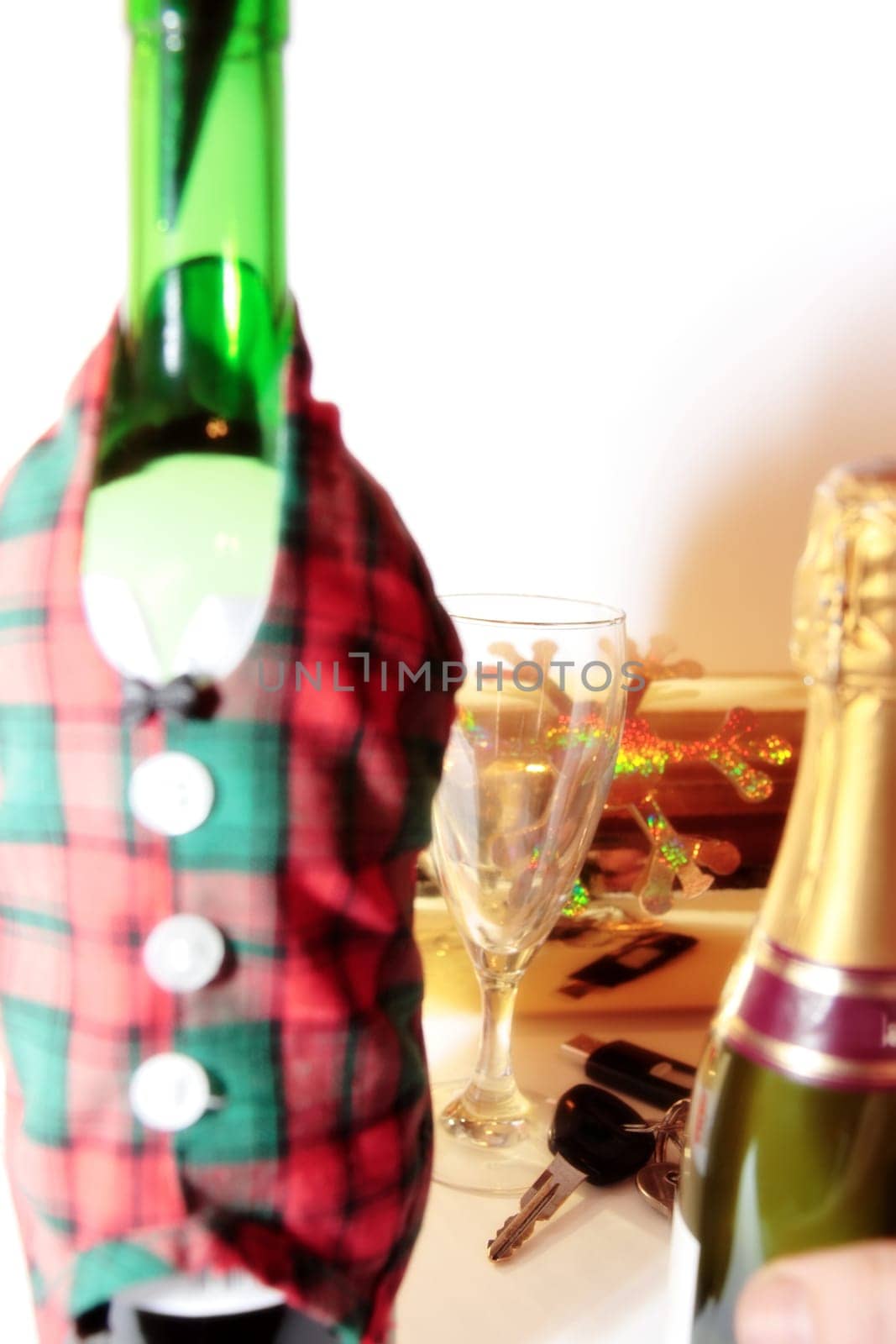 bottle dressed in jacket warmer with keys and alcohol on white background depicting drunk driving and addictions can kill