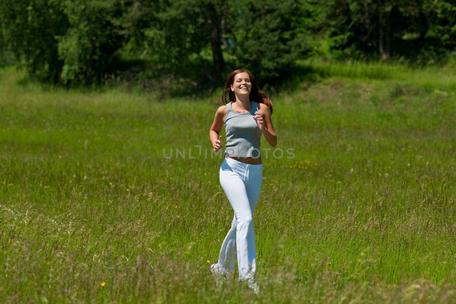 Young smiling woman jogging in the nature, shallow DOF