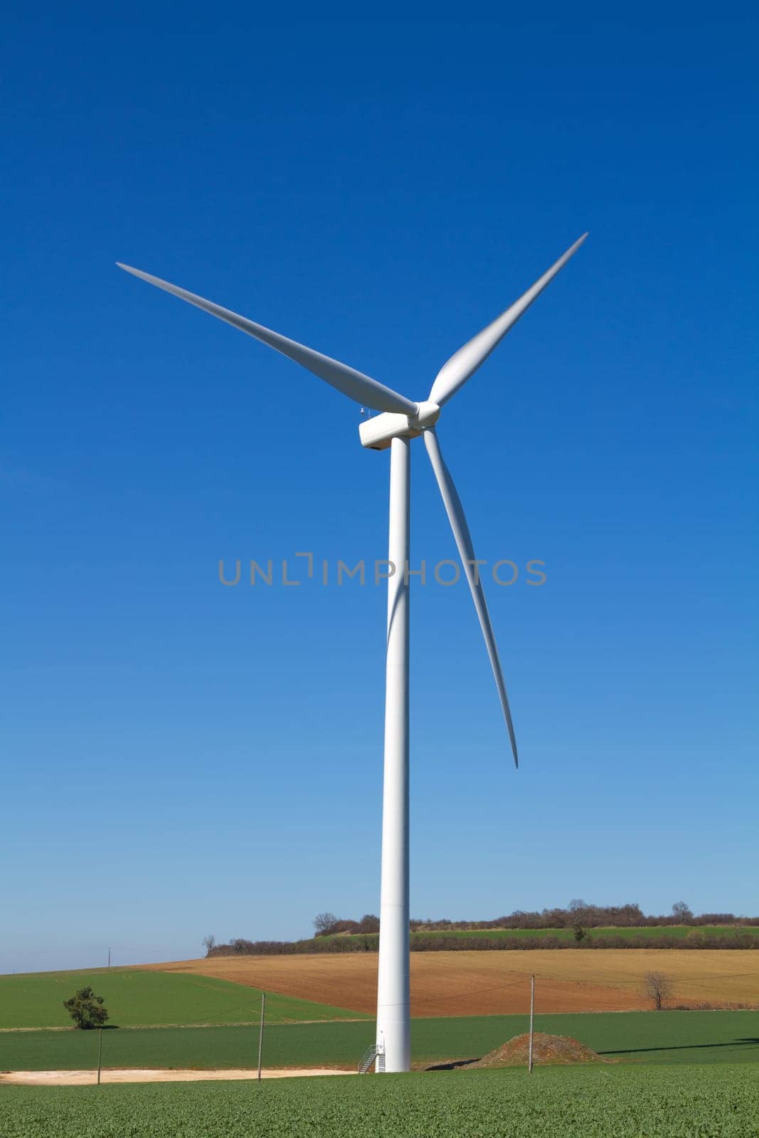A wind turbine under clear blue sky