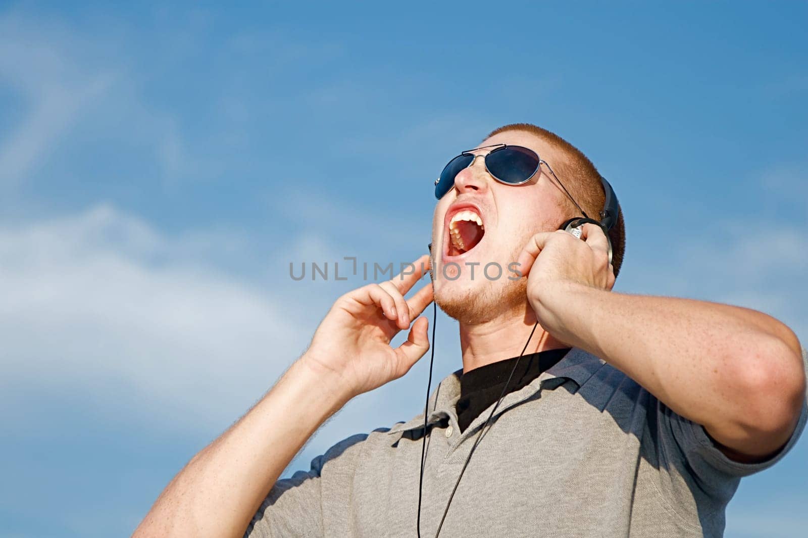 A cool young man listens to music on some headphones