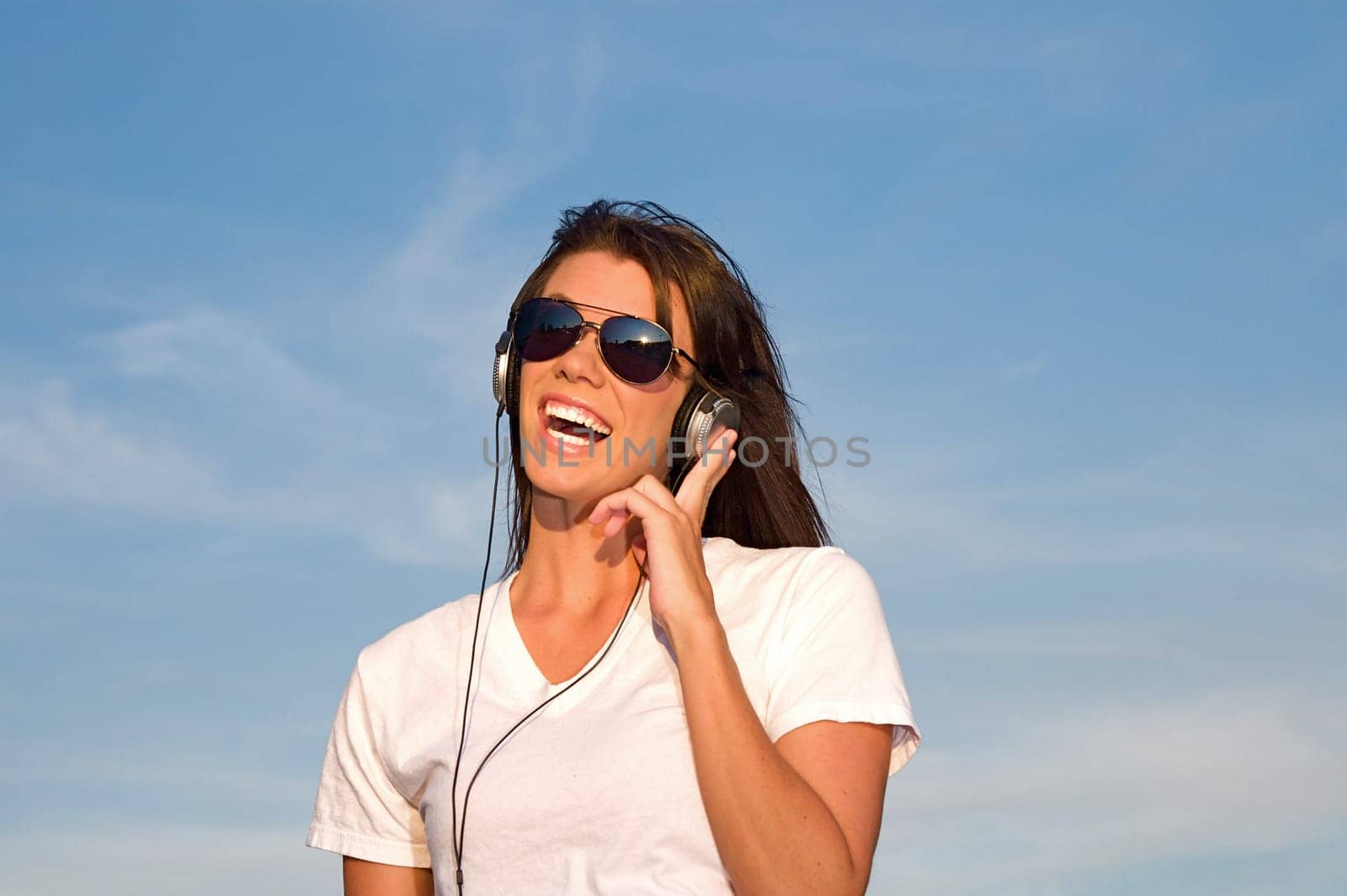 A cool young woman listens to music on some headphones