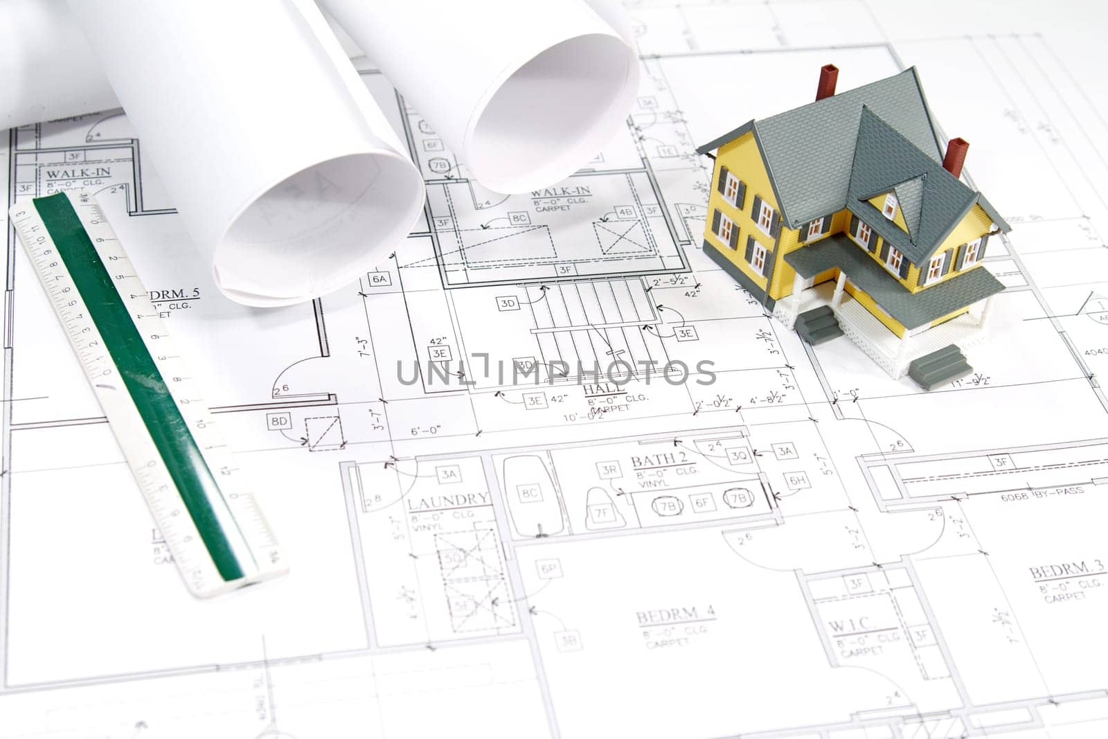 Residential home blueprints with a hand-made house model.