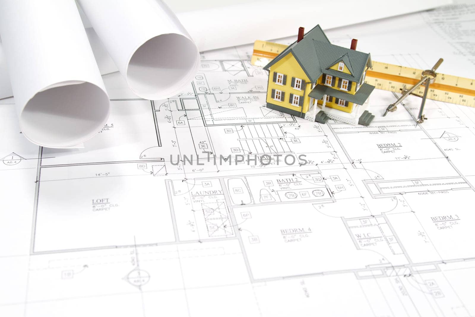 Residential home blueprints with a hand-made house model.