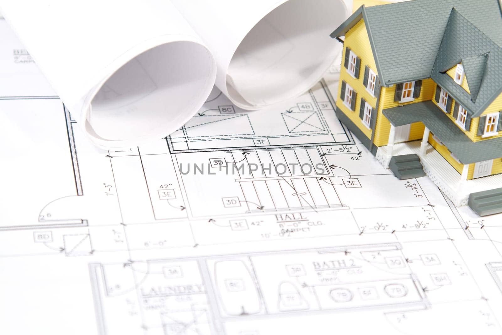 Residential home blueprints with a hand-made house model.