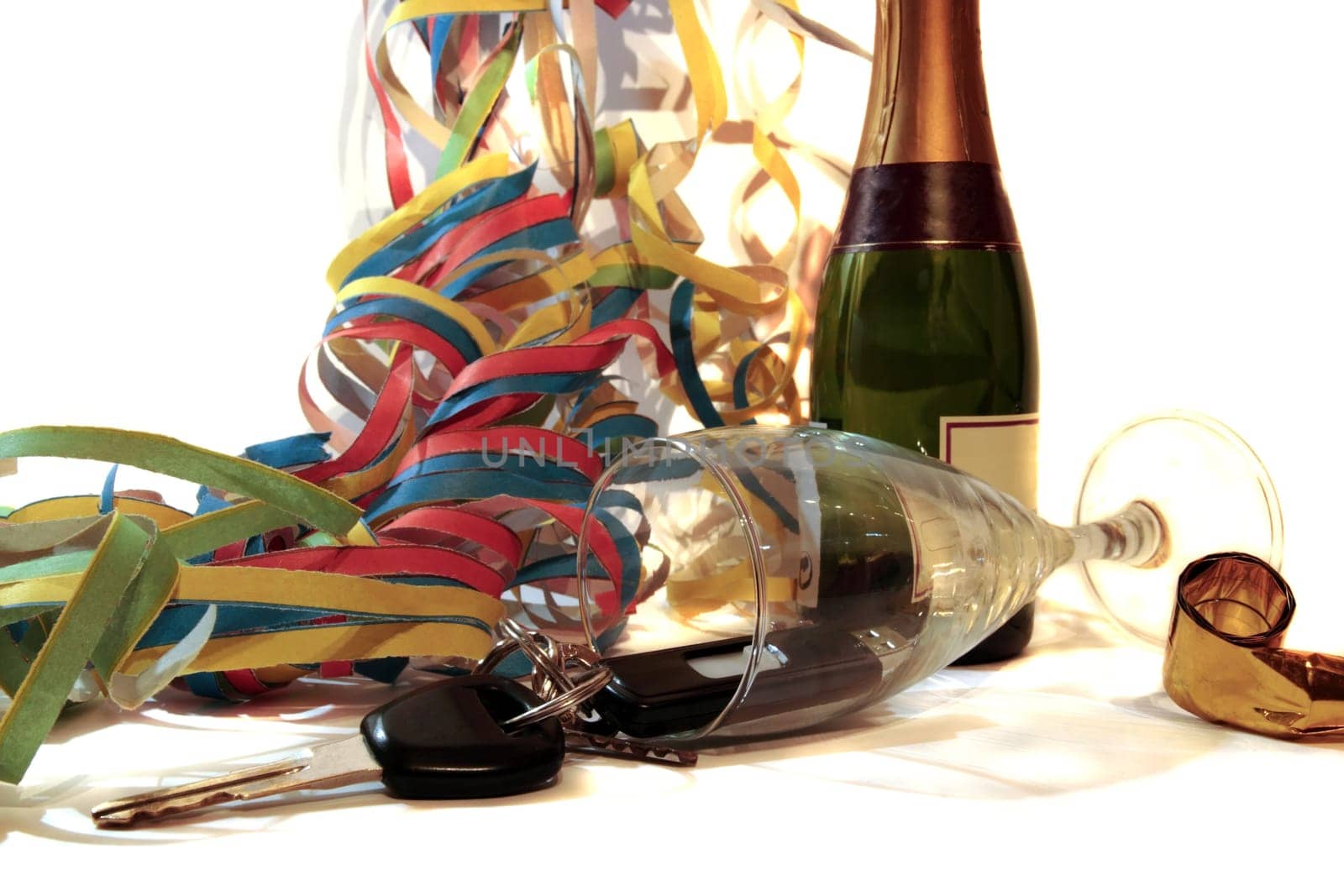 champagne with keys inside fallen glass on white background depicting drunk driving and addictions can kill