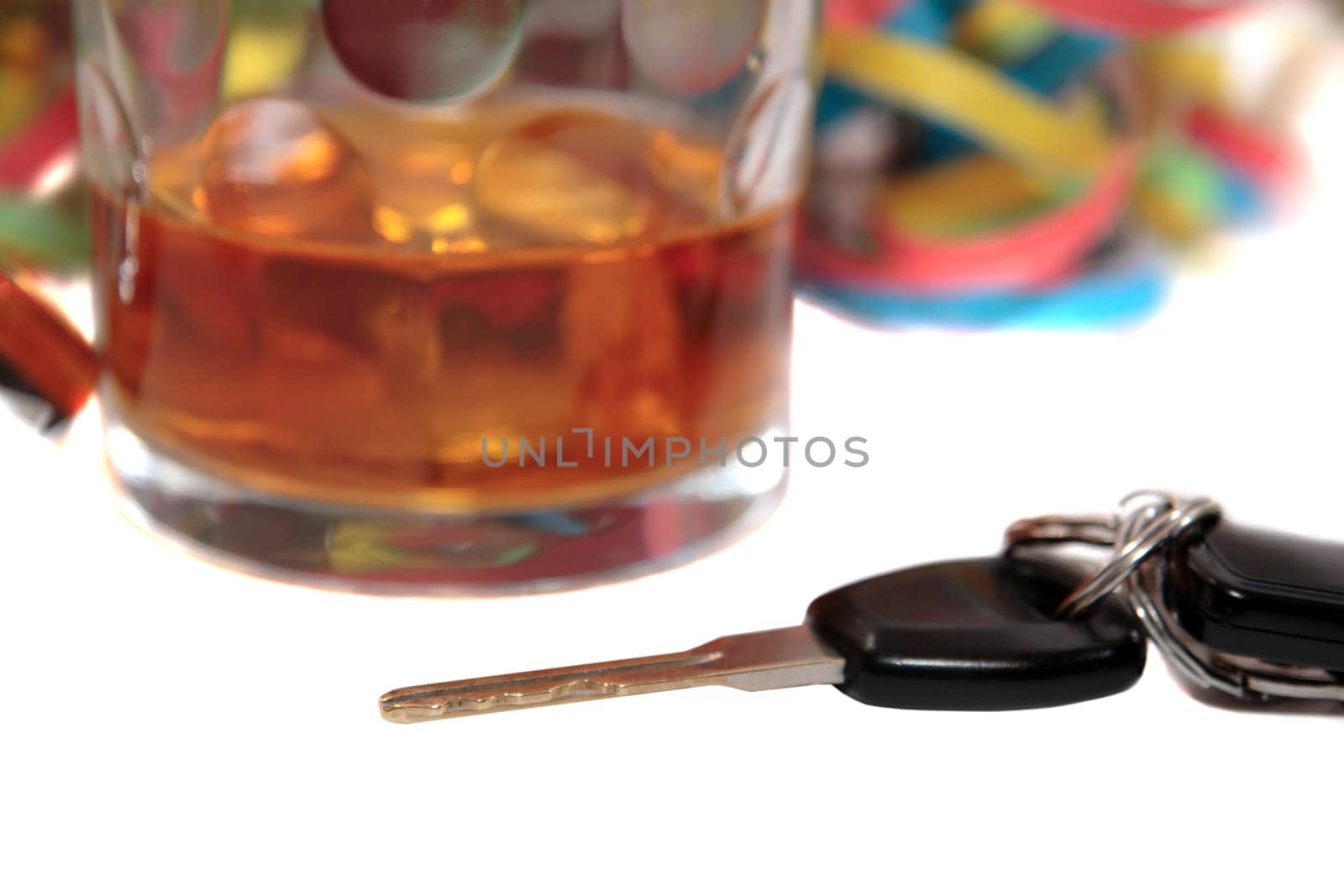 whiskey glass with car keys on white background depicting drunk driving and addictions can kill